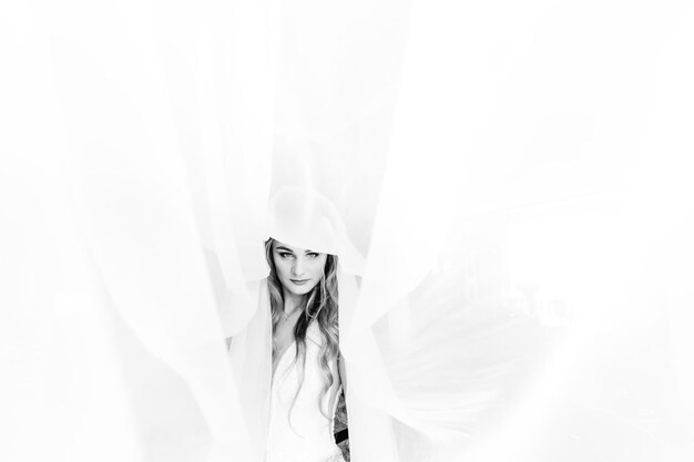 Bride in elegant wedding dress looks into the camera and tulle a