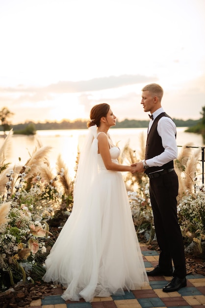 Bride and groom against the backdrop of a yellow sunset