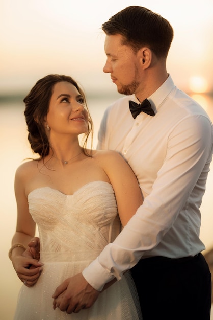 bride and groom against the backdrop of a yellow sunset