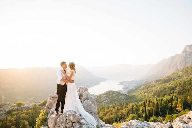 The bride and groom are embracing on Mount Lovcen, a picturesque panoramic view of the Bay of Kotor