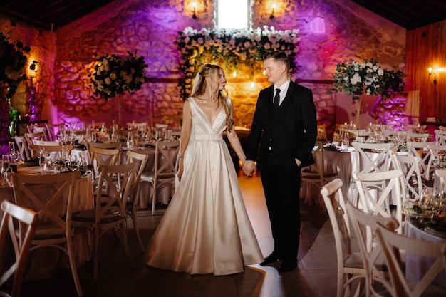 a bride and groom are holding hands in front of a wedding venue