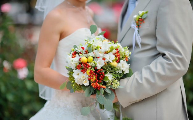 Bride and groom are holding wedding flower bouquet