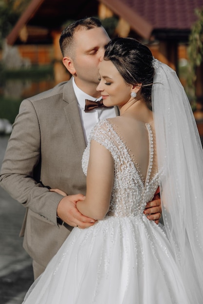 A bride and groom are hugging each other in a wedding photo