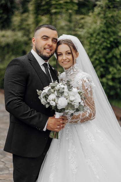 Photo a bride and groom are posing for a picture with a bouquet of flowers