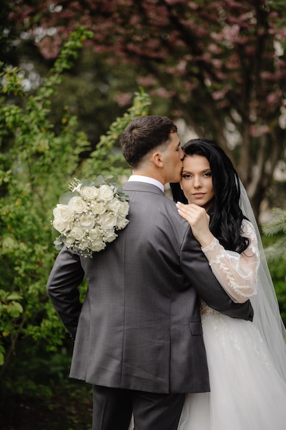 Bride and groom embrace in the garden