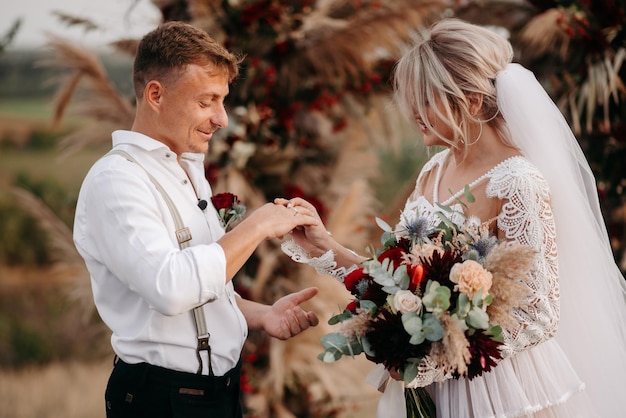 A bride and groom exchange rings at a wedding ceremony.