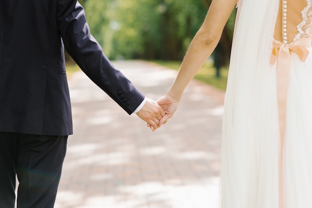 The bride and groom hold each other's hands. Loving couple