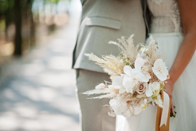 Bride and groom holding beautiful tender wedding bouquet