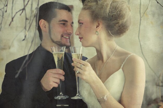 bride and groom holding glasses with champaign in vintage room