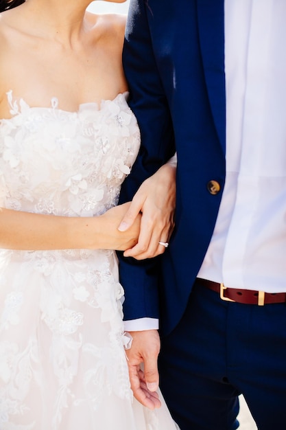 Bride and groom holding hands together Close up Fine art style