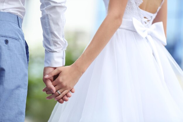 Bride and groom holding hands together outdoor