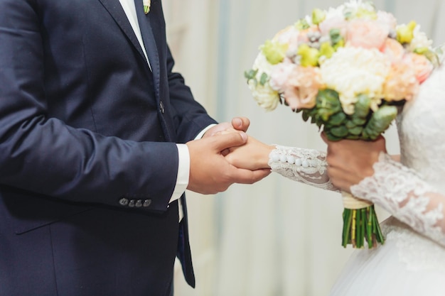 Bride and groom holding hands at the wedding ceremony