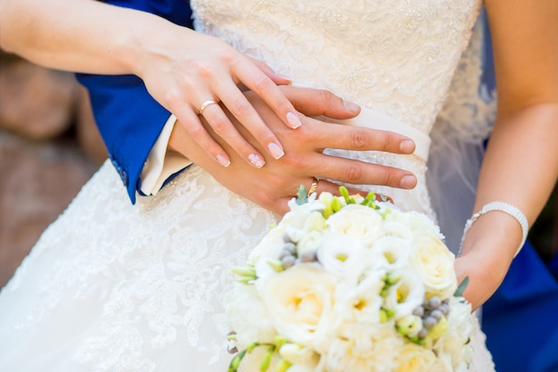 Bride and groom holding hands with a bouquet