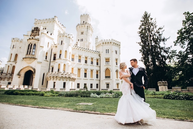 Bride and groom hug, kiss outdoors on wedding day, young couple walk in Prague, valentine's day