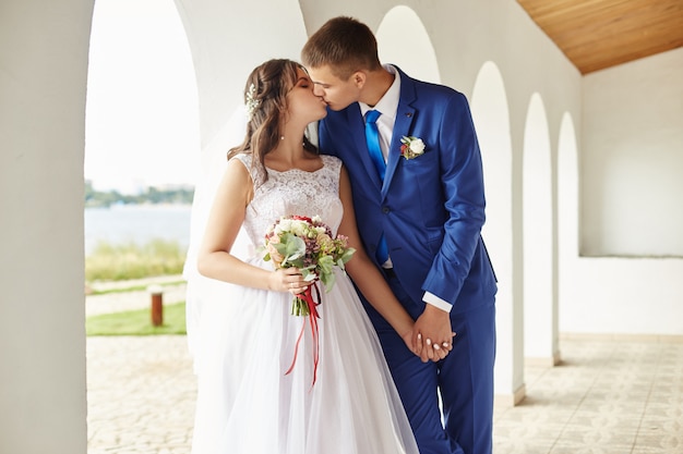 Bride and groom hug and kiss at the wedding