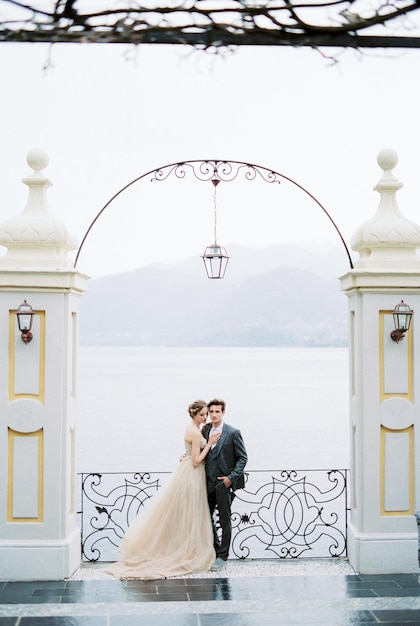 Bride and groom hugging under the arch on the embankment