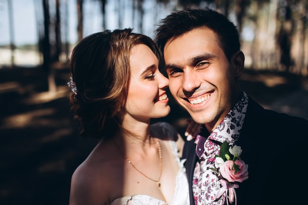 Bride and groom hugging, kissing outdoors on a wedding day, young couple, valentine's day