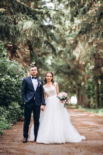 Bride and groom hugging, kissing outdoors on a wedding day, young couple, valentine's day