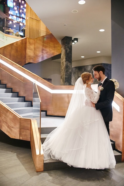 Bride and groom hugging and kissing on the stairs