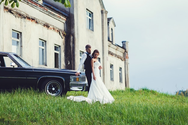 bride and groom hugging near a car outdoor