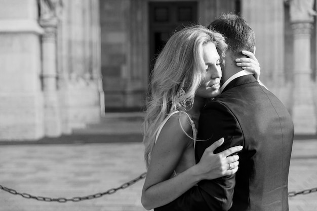 Bride and groom hugging in the old town street. Wedding couple in love. Luxury rhinestone dress.