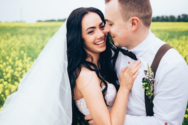 Photo bride and groom hugging on wedding day, happy young couple kissing in park in nature, valentine's day