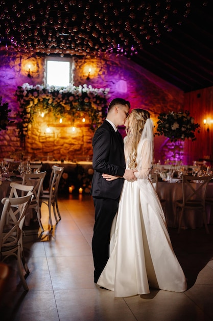 a bride and groom kiss in front of a stone wall