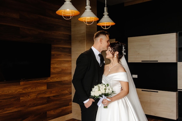 a bride and groom kiss in a room with lights