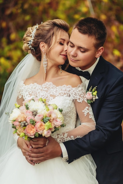 Bride and groom kissing in a park The newlywed couple in nature yellow forest