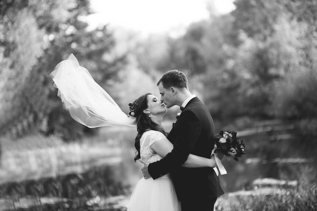 Bride and groom kissing at park