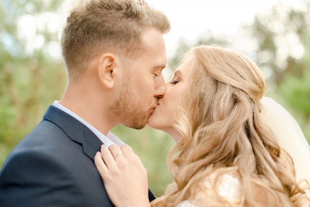 Bride and groom kissing in the park