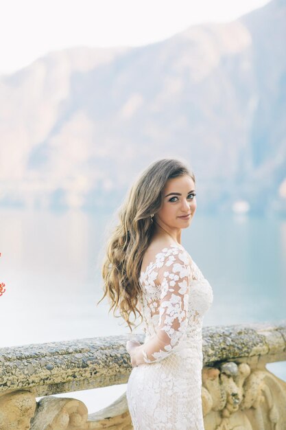 bride and groom long veil and white dress on mountains background lake Como Italy