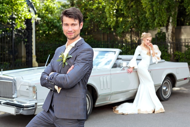 The bride and groom near retro car. Wedding. Groom portrait close up