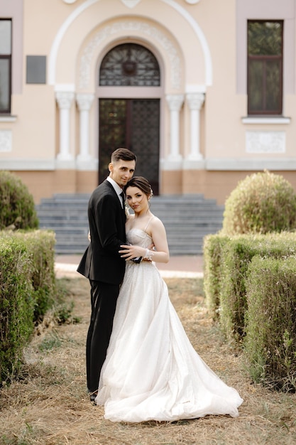 the bride and groom pose in front of a pink house