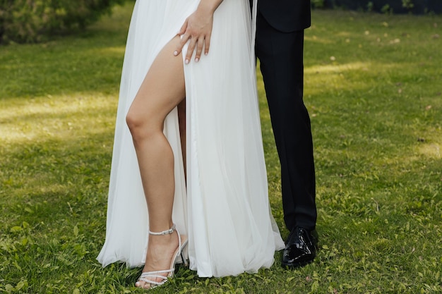 A bride and groom pose for a photo in a field.