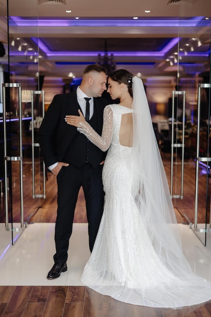 a bride and groom pose for a photo in front of a mirror