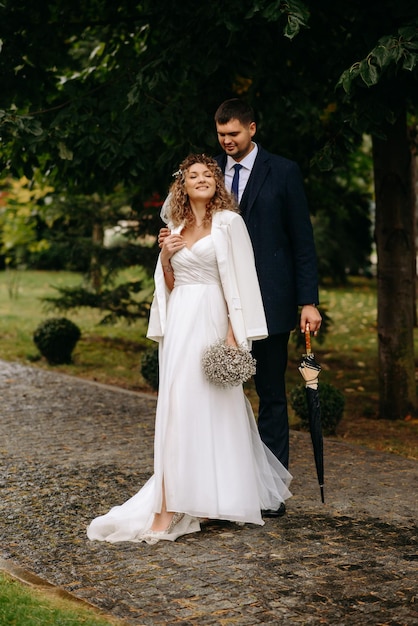 a bride and groom pose for a photo in front of a tree