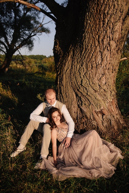 Bride and groom posing in the forest at sunset