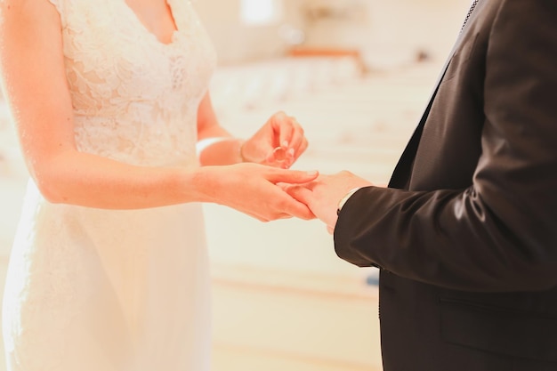 A bride and groom putting on their wedding rings