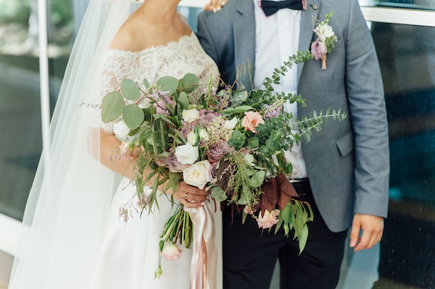 Bride and groom together holding wedding bouquet