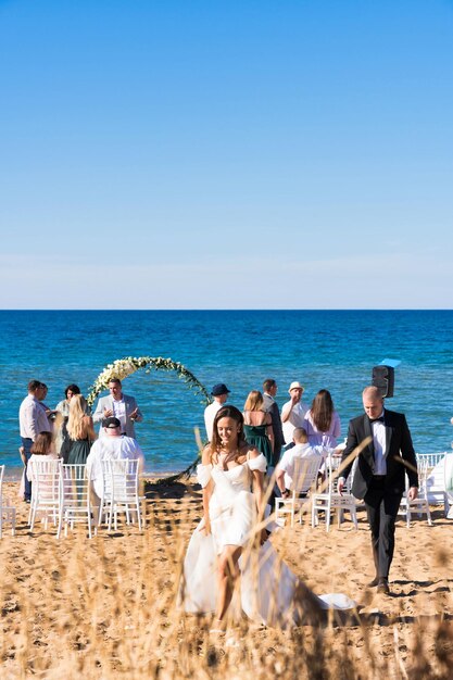 Photo a bride and groom walk along a beach with a bride and groom