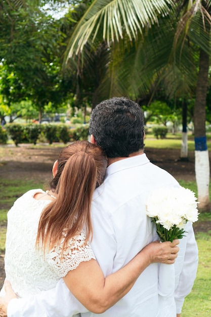 Bride and groom walking under the trees during the vow renewal