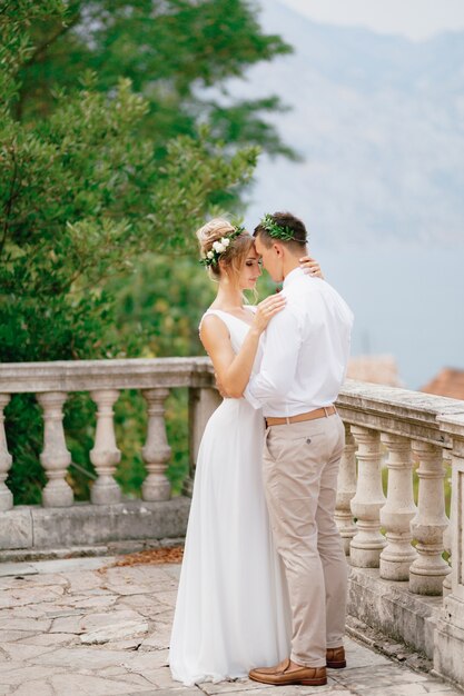 The bride and groom in wreaths tenderly embrace