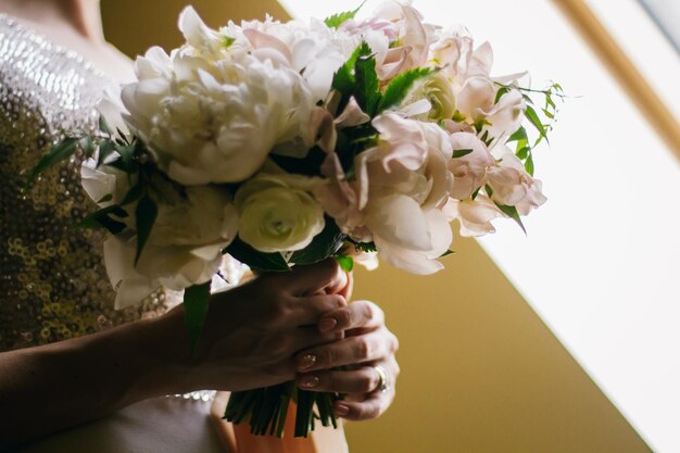 bride holding bouquet of flowers. the bride holds a bouquet in her hands.