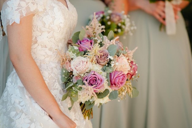 Bride holding bridal bouquet with different shades of pink roses and eucalyptus leaves