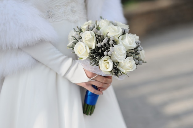 Bride Holding wedding Bouquet of White Roses.