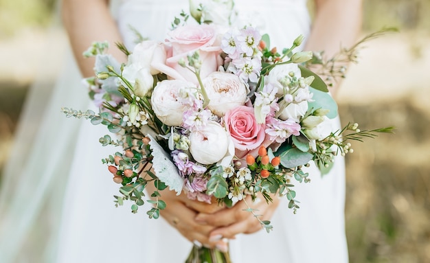 Bride holding wedding bouquet with white and pink flowers