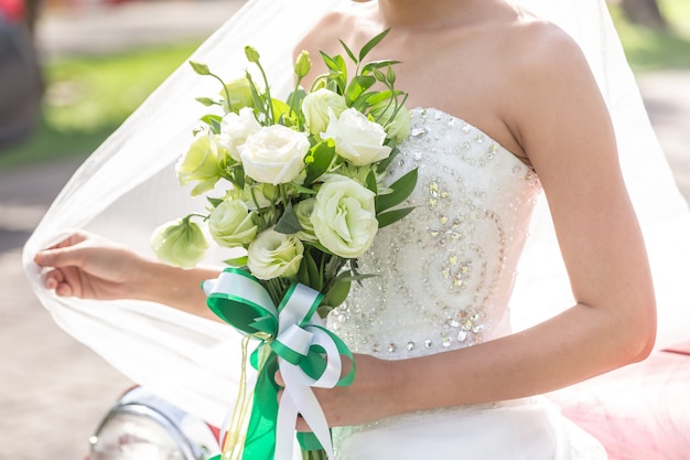 The bride holds a beautiful bouquet of white flowers