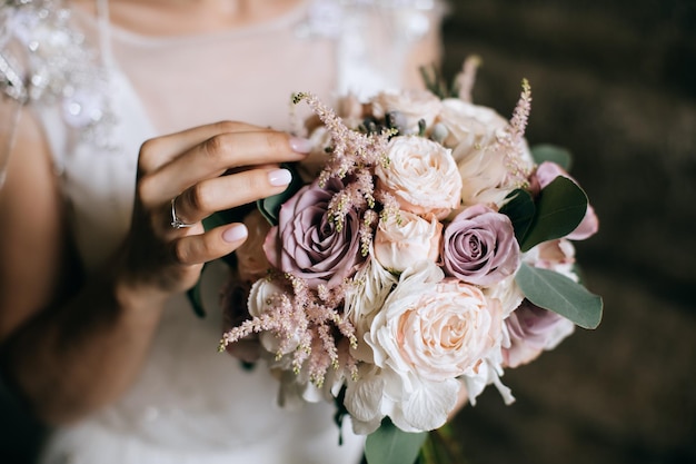 The bride holds a beautiful wedding bouquet of pink and white flowers in her handsx9