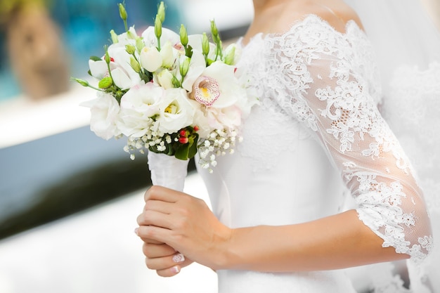 The bride holds the beautiful wedding bouquet